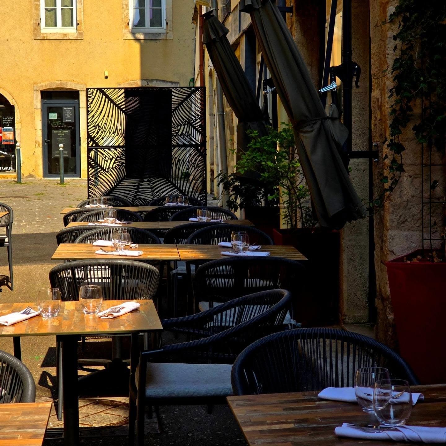 La terrasse du restaurant L'Adresse dressée dans la ruelle de l'Orveau à Dole, à la lumière du soir