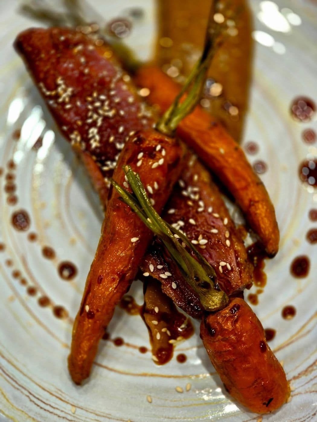 Carottes rôties au sésame, dressées dans une assiette en grès au restaurant L'Adresse à Dole
